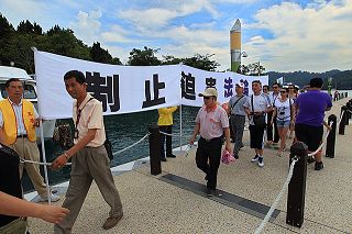 广东旅游团八月十九日下午由日月潭玄光寺下船，随即入眼的是法轮功学员举的制止迫害法轮功的横幅，黄华华因惧怕最终未上岸。